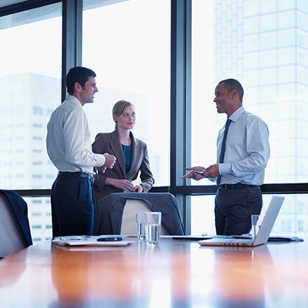 Three Businesspeople Standing in a Boardroom